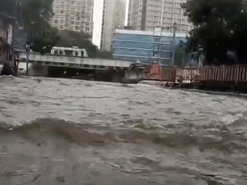 मुंबई के अंधेरी ईस्ट इलाके में शुक्रवार को बारिश के बाद सड़कों पर पानी भर गया।
