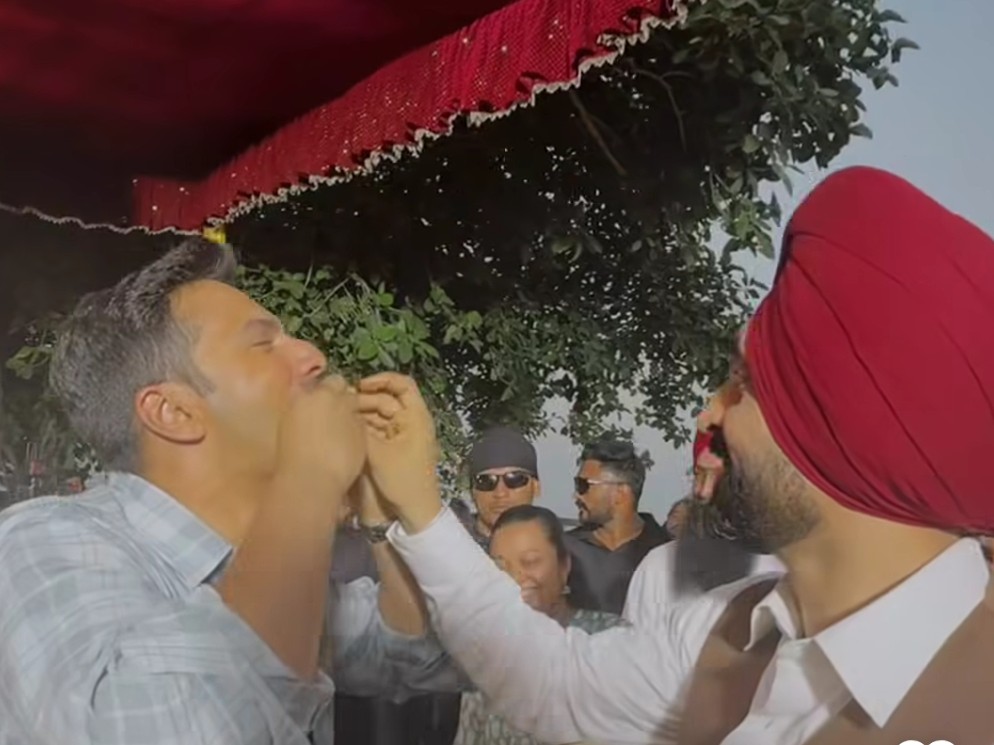 वरुण धवन को लड्डू खिलते हुए दिलजीत दोसांझ।