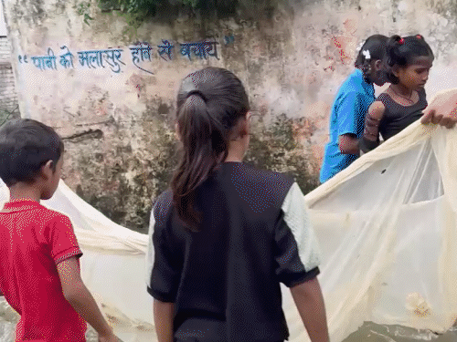 सड़क पर पानी बहने से बच्चे मछली पकड़ने लगे।