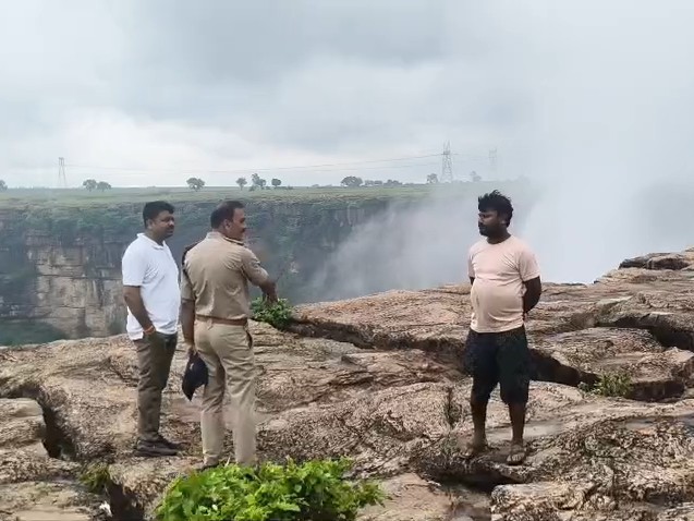 पहाड़ी पर मौजूद लोगों को समझाते पुलिसकर्मी।