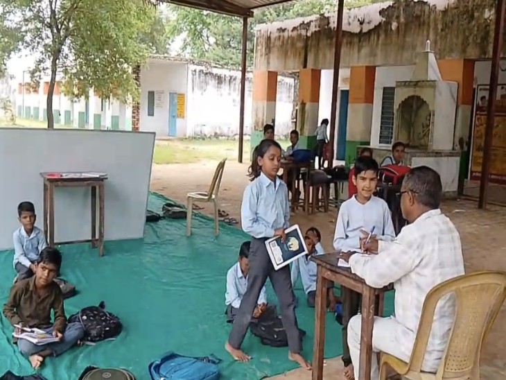खुले आसमान के नीचे बैठकर पढ़ते हुए बच्चे।