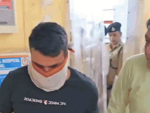 दूसरे की जगह एग्जाम देने वाले आरोपी को हिरासत में लेती पुलिस।