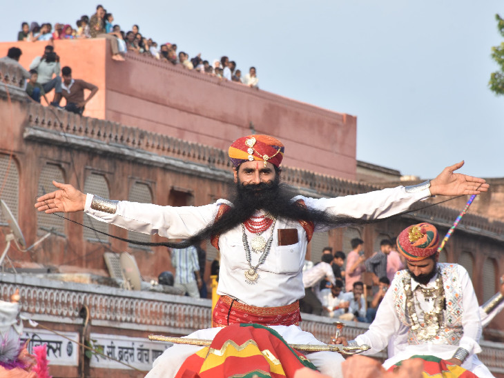 तीज माता की सवारी में ऊंट पर बैठा एक कलाकार अपनी अनोखी मूछें लोगों को दिखाया हुआ।
