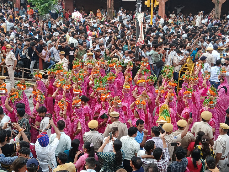 गुलाबी रंग के लहरिया में महिलाएं सिर पर कलश लिए तीज की सवारी में शामिल हुईं.
