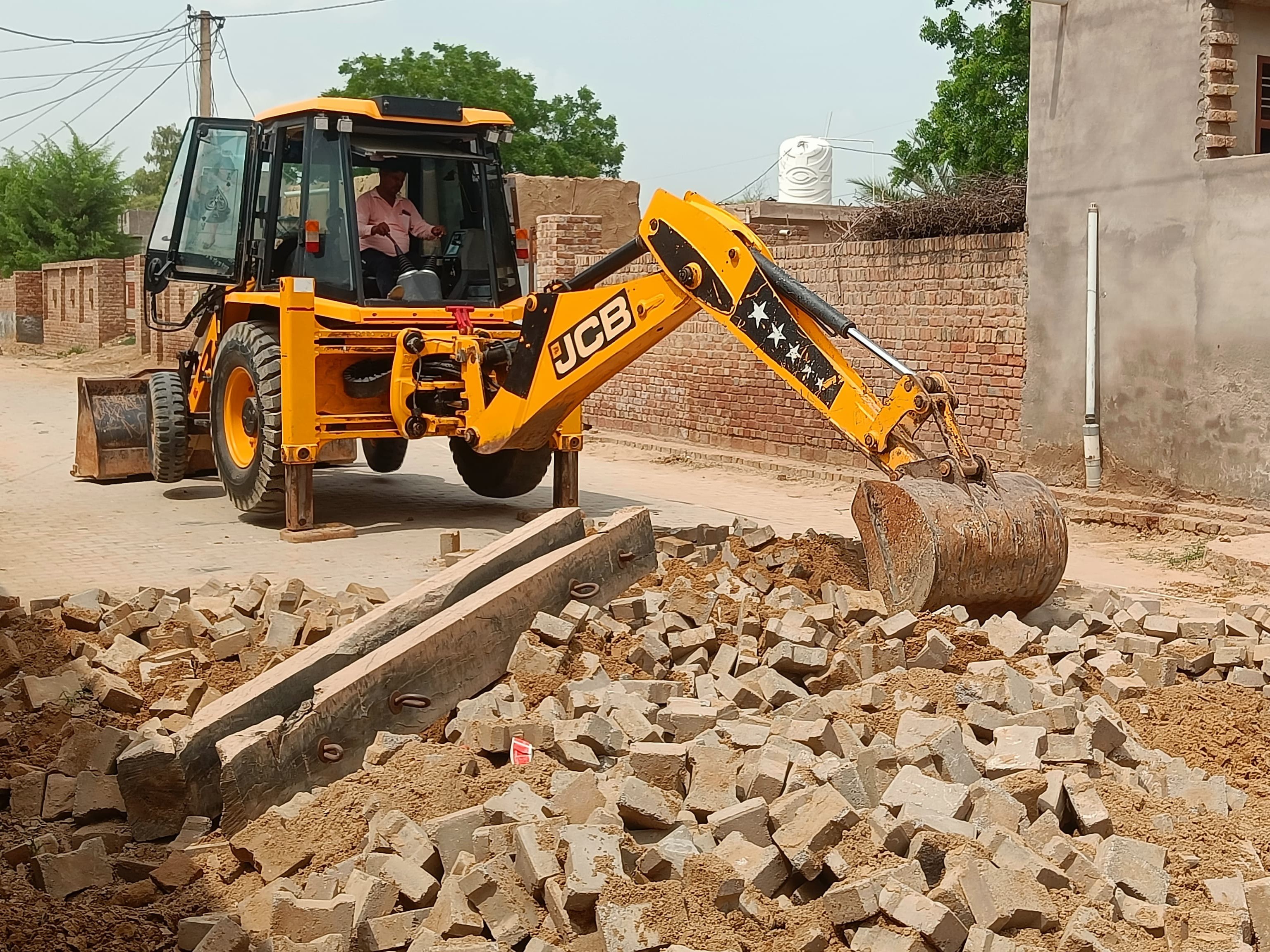 जेसीबी की मदद से इंटरलॉकिंग को तोड़ा गया।