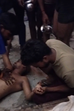 मंदिर में करंट लगने के बाद दो लोग जमीन पर गिरकर अचेत हो गए। तस्वीर में गंभीर रूप से घायलों को CPR देकर लोगों ने बचाने की कोशिश की, लेकिन बचाया नहीं जा सका।