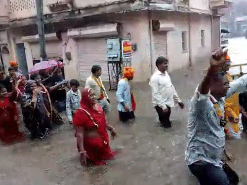 राजस्थान के सवाई माधोपुर में मंगलवार को बारिश के दौरान पुराने शहर में ठाकुरजी की शोभायात्रा निकाली गई। लोग भजनों पर नाचते-गाते हुए घुटनों तक पानी से गुजरे।