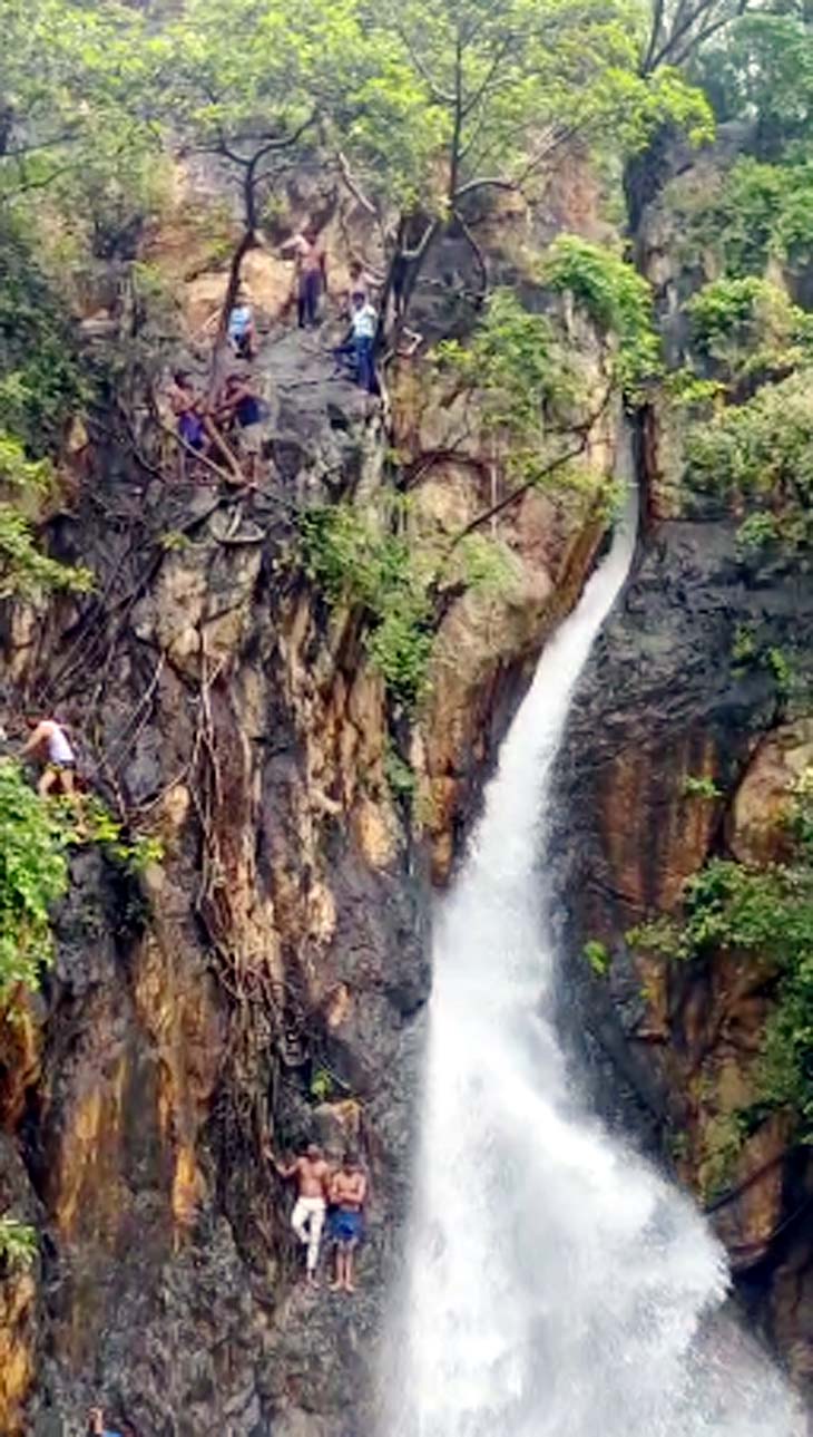 पहाड़ के ऊपर चढ़कर युवक कई फीट उपर से छलांग लगाते हैं