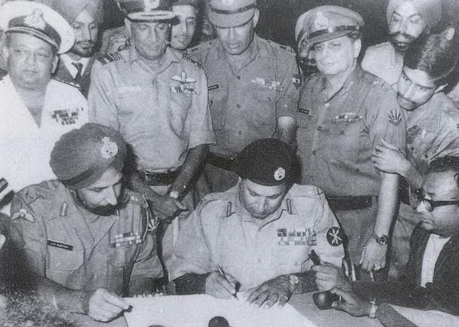 1971 युद्ध के दौरान सरेंडर के डॉक्यूमेंट पर दस्तखत करते पूर्वी पाकिस्तान के गर्वनर लेफ्टिनेंट जनरल के जनरल नियाजी। साथ में इंडियन आर्मी के लेफ्टिनेंट जनरल जेएस अरोरा बैठे हैं।
