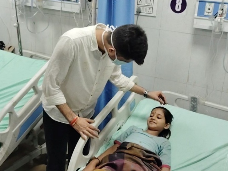 झालावाड़ अस्पताल में स्कूल हादसे में घायल हुई बच्ची से बात करते निर्मल चौधरी।