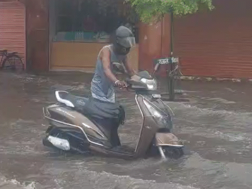 स्कूटी सवार भी बारिश के पानी में परेशान होते दिखे। तस्वीर चांदी की टकसाल के सामने भरे पानी की है।