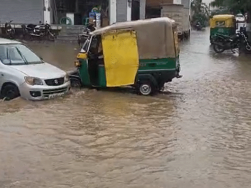 मानसरोवर स्थित भवन नगर कॉलोनी में तेज बारिश के कारण ऑटो गड्ढे में फंस गया।