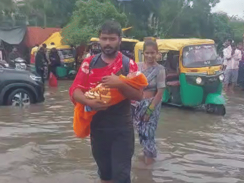 जेकेलोन अस्पताल के बाहर बच्चे को गोद में ले जाते हुए दिखे परिजन।
