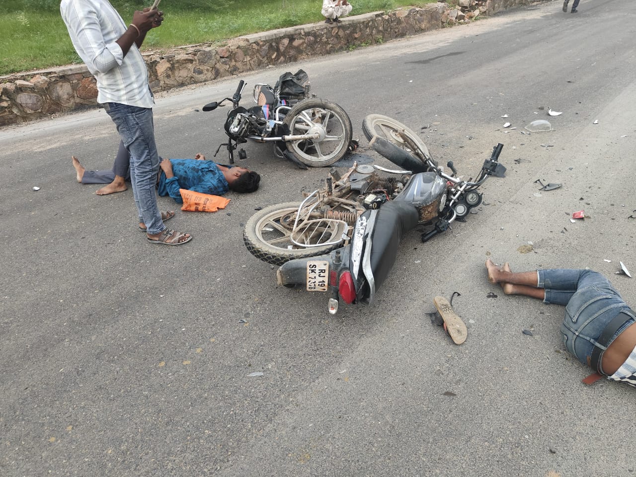 दुर्घटना के बाद सड़क पर पड़े क्षतिग्रस्त वाहन व घायल