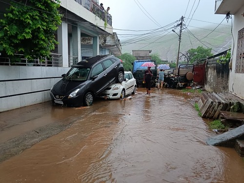 सवाई माधोपुर के पुराने शहर की बरकत कॉलोनी में पानी के तेज बहाव से गाड़ियां बहते हुए एक-दूसरे पर चढ़ गई हैं।