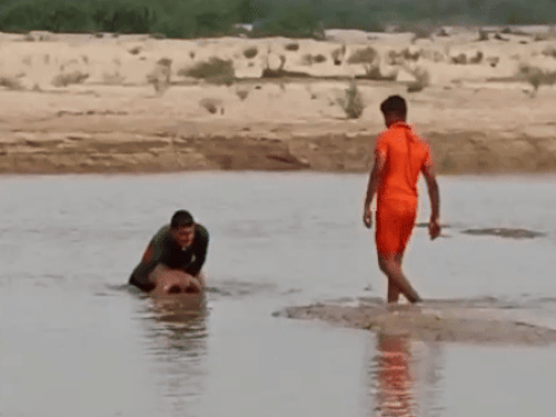 पानी से डूबे युवक के शव को बाहर निकालते हुए एसडीआरएफ की टीम