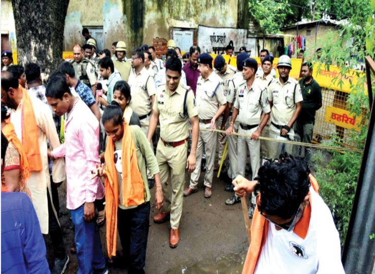 WRS कॉलोनी में हिंदू संगठनों द्वारा अस्थाई चर्च घेरने पर पुलिसकर्मी प्रदर्शनकारियों को हटाते हुए।