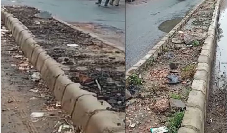 डिवाइडर पर पौधे की जगह कूड़ा भरा हुआ है।