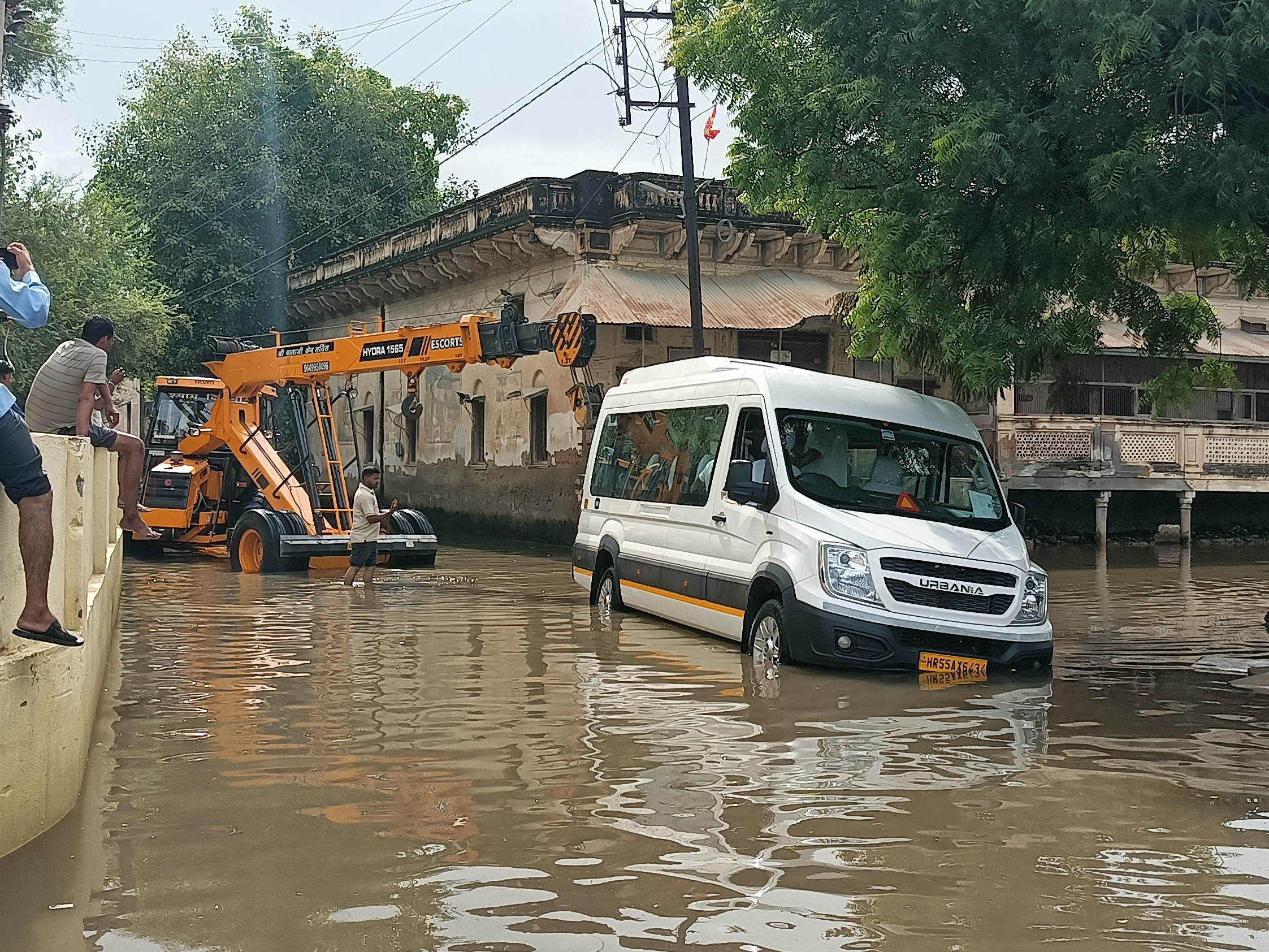 क्रेन से मिनी बस को बाहर निकालते हुए।