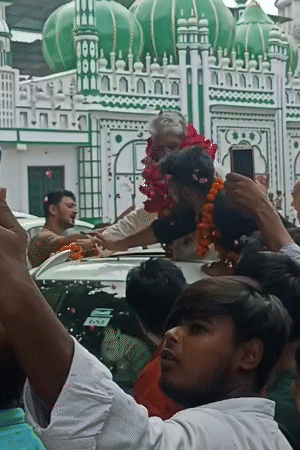 Sadar Zafar Ali of Jama Masjid rode in an open jeep. Supporters garlanded him.
