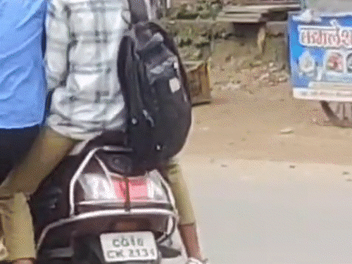 स्कूटी पर 5 बच्चे बैठे और एक छात्र खड़ा दिख रहा है।