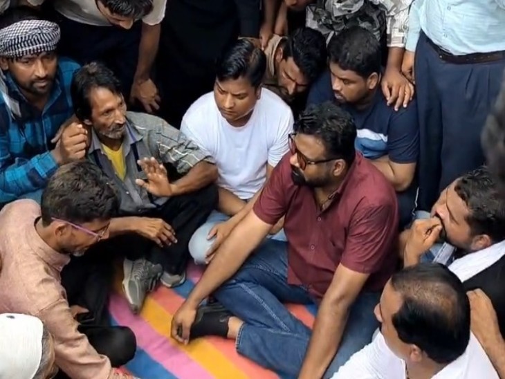 धरने पर बैठे परिजनों और लोगों को समझाते तहसीलदार मानवेंद्र जायसवाल (लाल कलर की शर्ट पहने हुए )
