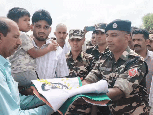 शहीद राजेंद्र के पिता रामनिवास और बेटे दिव्यांश को तिरंगा सौंपते सेना के अधिकारी।