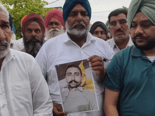 पाकिस्तानी जेल में बंद बेटे अमृतपाल सिंह की फोटो दिखाते उसके पिता जुगराज सिंह।