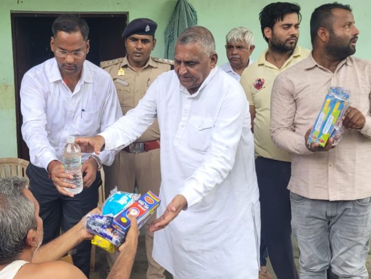 बाढ़ पीड़ितों को राहत सामग्री बांटते हुए अकबरपुर के सांसद देवेंद्र सिंह और घाटमपुर के एसडीएम अविचल प्रताप सिंह