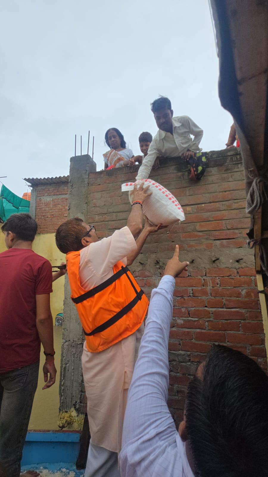 विधायक नीलकंठ तिवारी बोट से बाढ़ में फंसे लोगों के घर पहुंचे और राशन दिया