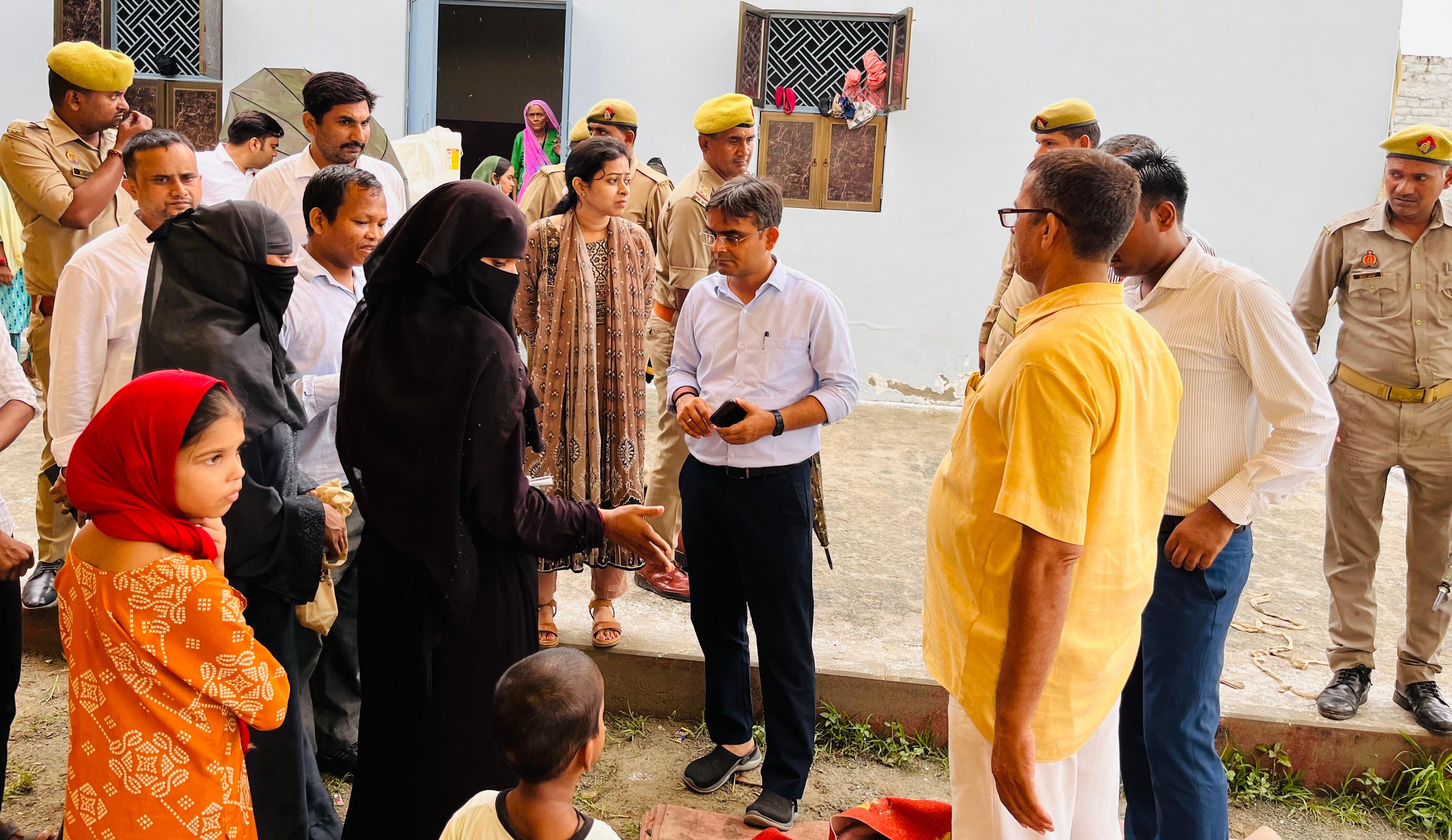 बाढ़ राहत शिविर में ठहरे लोगों से वार्ता करते डीएम
