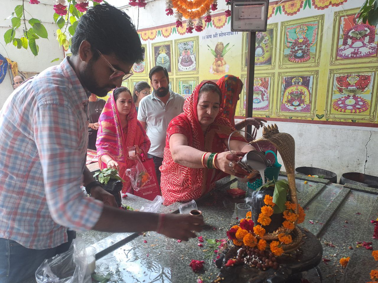 सोमनाथ महादेव मंदिर में शिव लिंग पर जलाभिषेक करते श्रद्धालु।