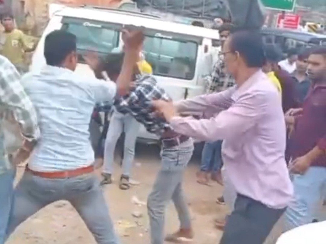 सड़क पर हाथापाई करते युवक।