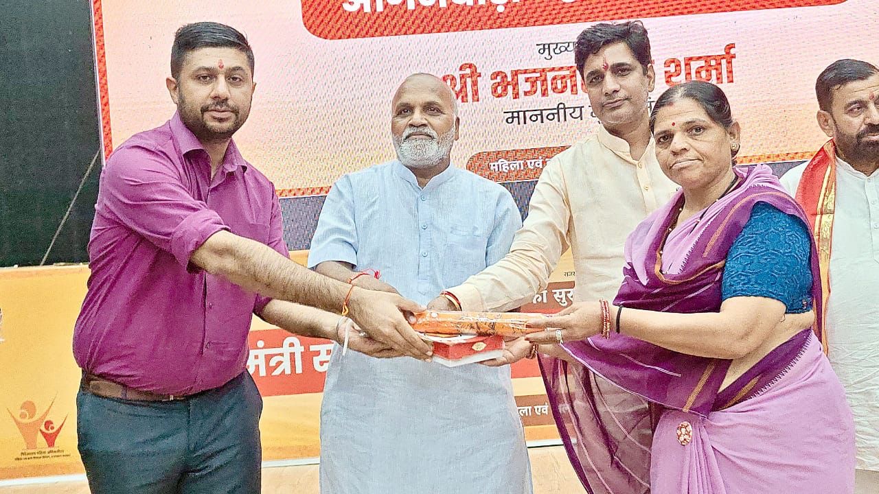 आंगनबाड़ी कर्मी को डीबीटी राशि देते अतिथि