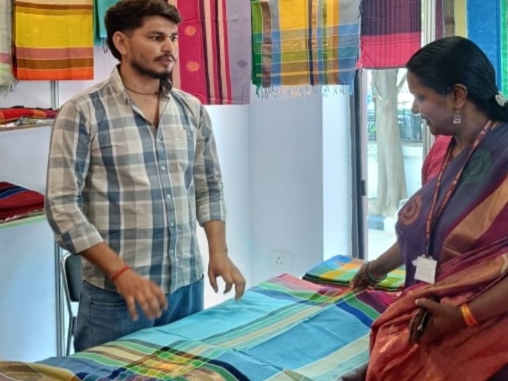 आशीष जैन द्वारा जयपुर में खोली गई कपड़ों की दुकान में साड़ी खरीदती महिला।