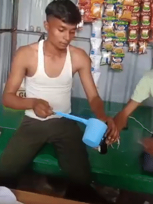युवक मग से शराब भरकर बॉटल में डालते हुए।