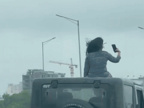 थार की छत पर बैठी युवती कैमरे में देखकर पोज देने में व्यस्त थी।