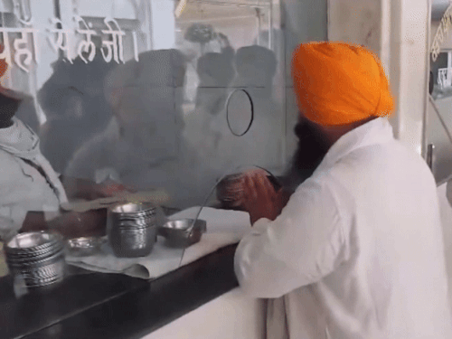 जूतों के सेवा के बाद कड़ाह प्रसाद लेते हुए मंत्री हरजोत बैंस।