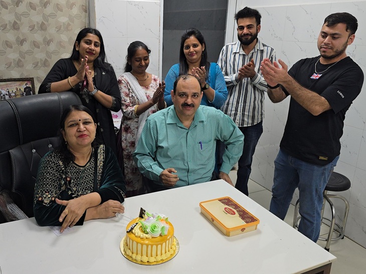 In this picture, Dr. Monica Poonia is sitting with her husband Raghuveer Punia. The staff of the hospital stands behind them.