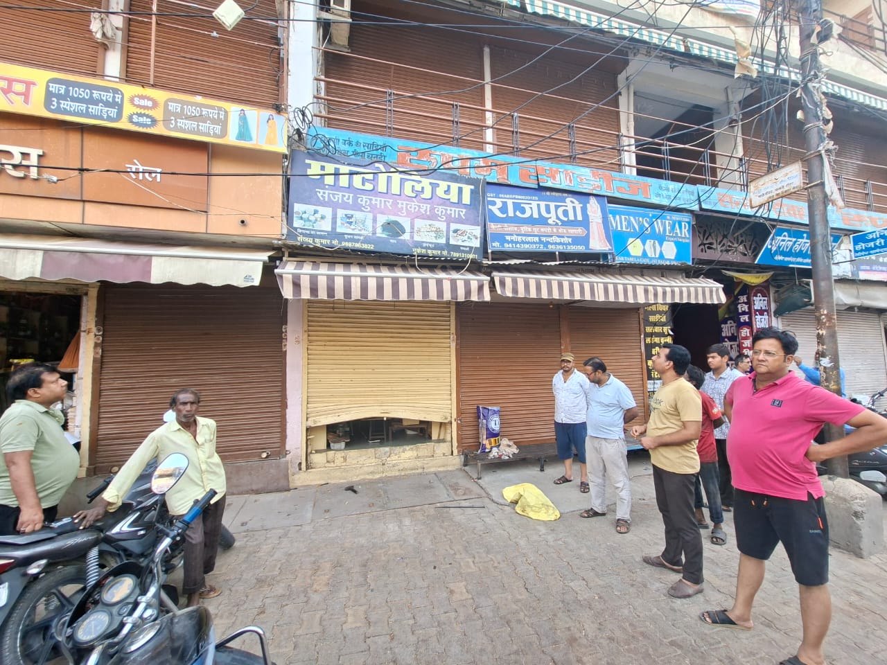 तबेला गेट के पास संजय कुमार मुकेश कुमार की दुकान के बाहर सुबह चोरी की सूचना मिलने के बाद मौजूद लोग।