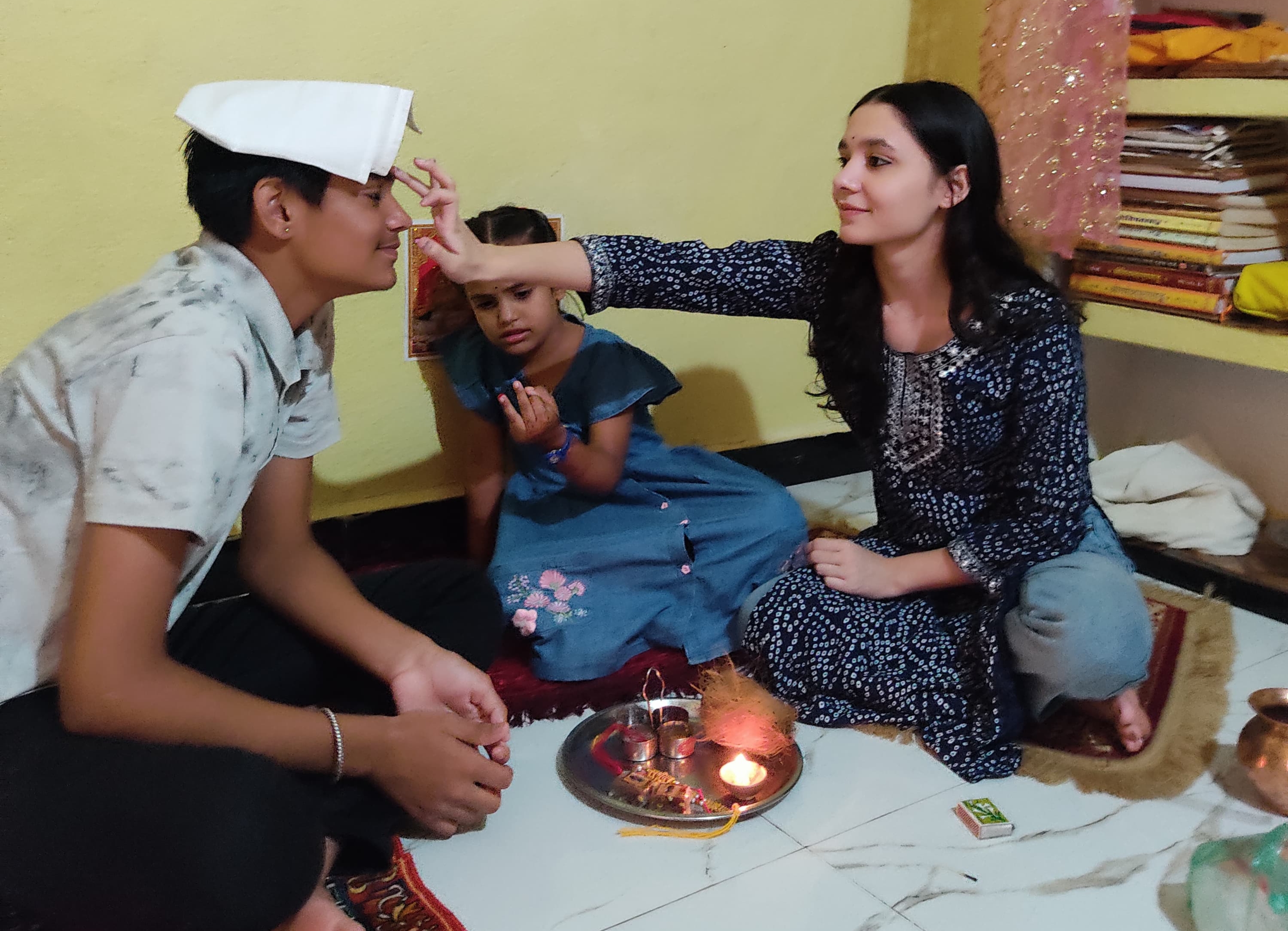 विवेक कॉलोनी में अपने भाई को राखी बांधती खुशी रघुवंशी और हर्षिका रघुवंशी।