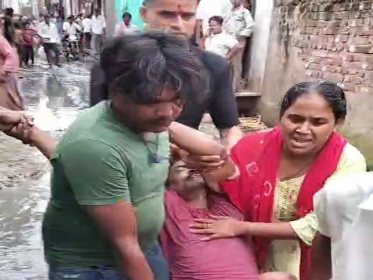 जलभराव के बीच से शव को अस्पताल ले जाते परिजन