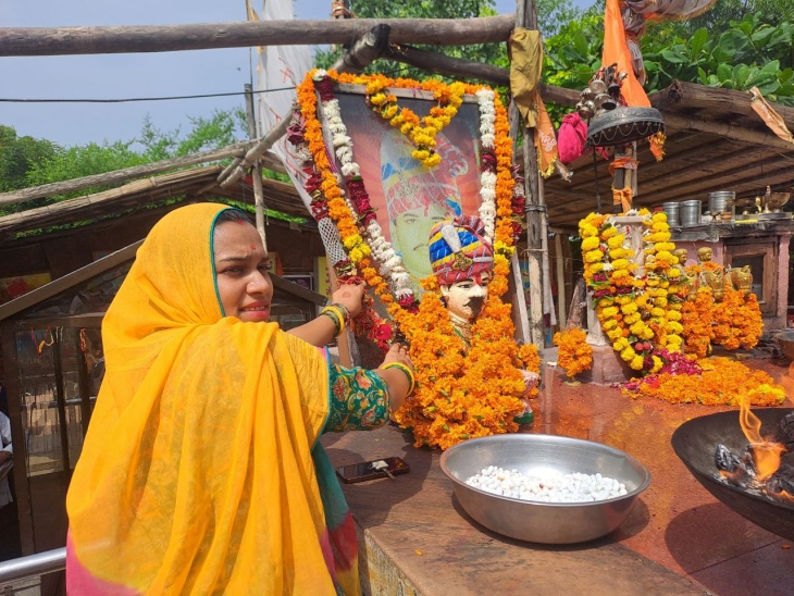 ओम बन्ना की तस्वीर पर राखी बांधती एक महिला।