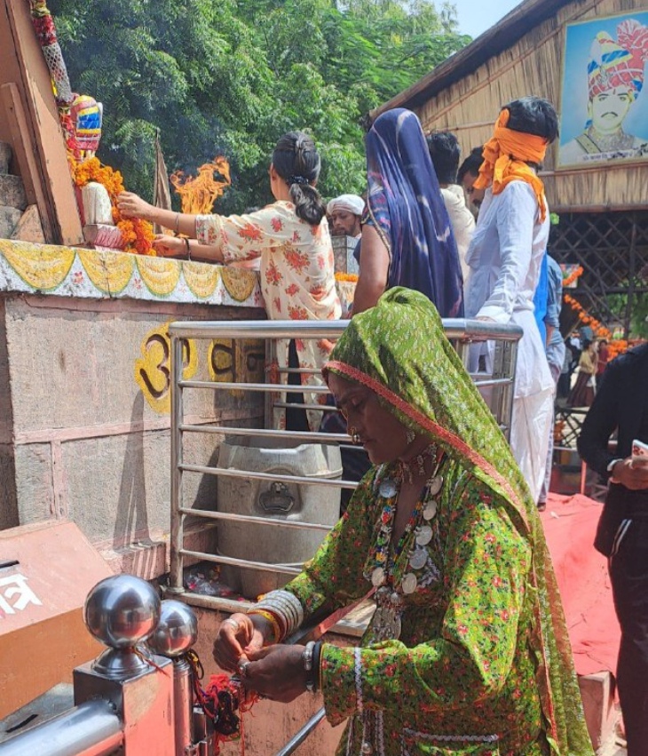 ओम बन्ना की बुलेट के आगे राखी बांधते हुए महिला।