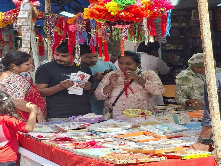रक्षाबंधन पर बाजार में राखी की स्टॉल पर खरीदारी करते हुए