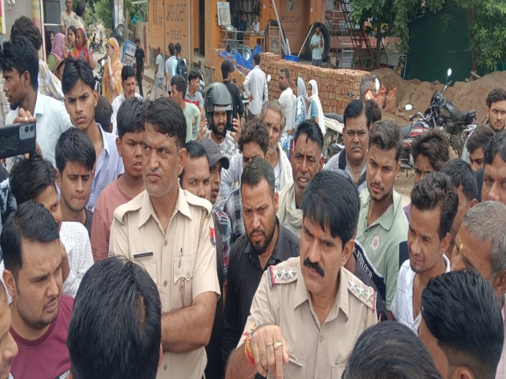 मौके पर जाम लगा रहे लोगों से समझाइश करते अलवर एनईबी थाने के एसएचओ दिनेश चंद।