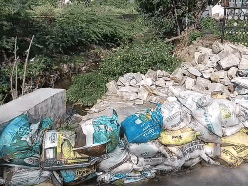 नाले की दीवार टूटी हुई और कट्‌टे लगाए गए है।