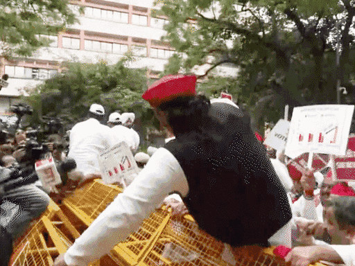 अखिलेश यादव ने दिल्ली में प्रदर्शन के दौरान बैरिकेडिंग फांदी।