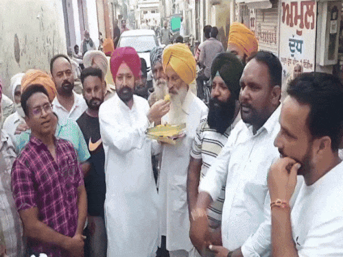 फतेहगढ़ साहिब से AAP के विधायक लखबीर सिंह राय ने पॉलिसी वापस लेने के ऐलान के बाद किसानों को लड्डू खिलाए।