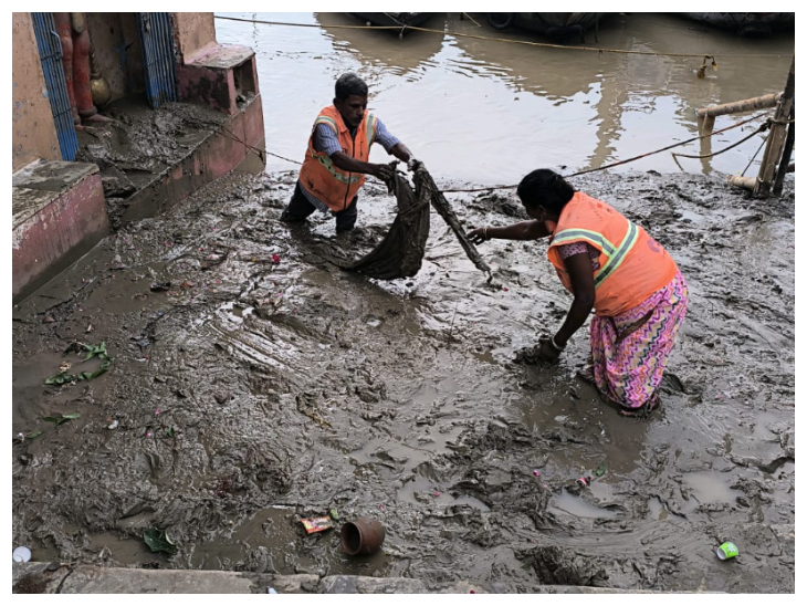 गंगा द्वारा लायी गयी सिल्ट से कूड़े को अलग करते सफाई कर्मी।